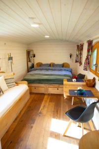 a bedroom with a bed and a couch in a room at La Tiny House de la Bergerie in Lierneux