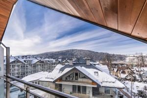 a view from the balcony of a building with snow covered roofs at Apartamenty Smile in Zakopane
