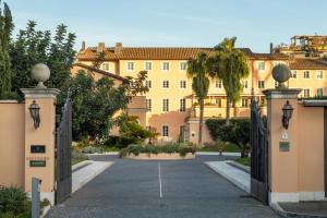 ein offenes Tor zu einem Gebäude mit einer Auffahrt in der Unterkunft Villa Agrippina Gran Meliá – The Leading Hotels of the World in Rom