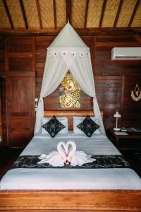 1 dormitorio con 1 cama con dosel en WOODEN HOUSE CANDIDASA en Manggis