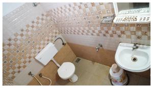 een kleine badkamer met een toilet en een wastafel bij Kay Kay Residency in Cochin