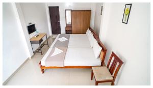 - une chambre avec un lit, une table et un bureau dans l'établissement Kay Kay Residency, à Cochin