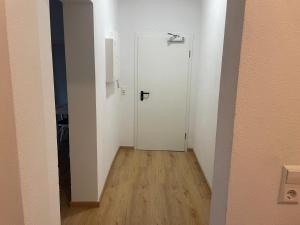 a hallway with a white door and a wooden floor at Timeless: 4 Zimmer Apartment Ludwigsburg in Ludwigsburg