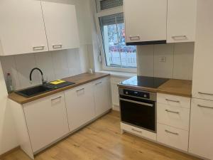 a kitchen with white cabinets and a sink and a window at Timeless: 4 Zimmer Apartment Ludwigsburg in Ludwigsburg