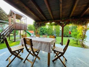 a table and chairs on a patio with a swing at Arpas Spirit in Arpaşu de Jos