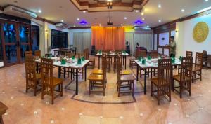 un restaurante con mesas y sillas y un hombre de fondo en Payamai Resort en Ban Nong Nam Khan