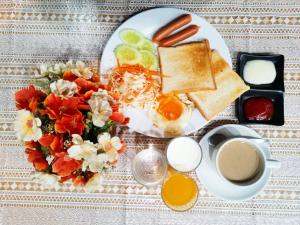 einen Teller mit Frühstücksfutter, Toast mit Eiern und eine Tasse Kaffee in der Unterkunft Sawasdee Siam Hotel in Pattaya