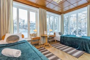 two beds in a room with windows at Gustav Ernesaks- Kadriorg in Tallinn