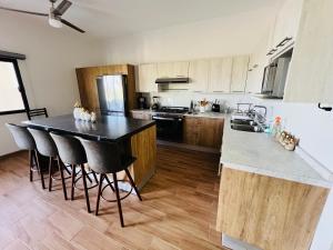 a kitchen with a black counter top and wooden cabinets at La Ventana Apartments #6 in La Ventana