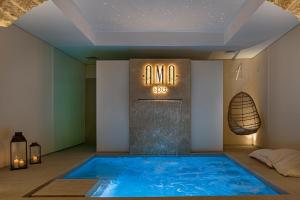 a large blue swimming pool in a room with a sign at Costamante Suites & Spa in Castellammare del Golfo