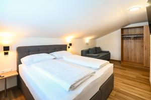 een slaapkamer met een groot wit bed en een stoel bij Club House by Schladming-Appartements in Schladming