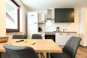 een keuken met een houten tafel en stoelen bij Club House by Schladming-Appartements in Schladming