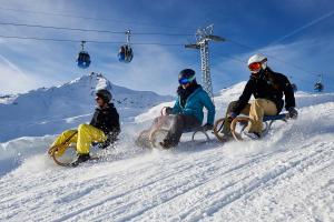 a group of three people riding down a snow covered slope at Rothornblick 04 by Arosa Holiday in Arosa