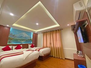 加德滿都的住宿－Hotel Dipjyoti，一间卧室设有两张床,墙上挂着一幅画