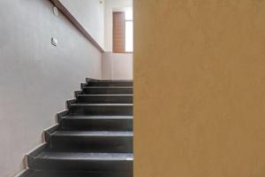 a staircase with black steps in a building at Collection O Sagayi International Resort in Hassan