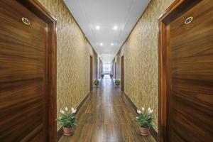 a hallway with wooden walls and potted plants at Collection O Sagayi International Resort in Hassan