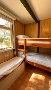 Camping Las Palmeras في كريفايلنت: غرفة بها ثلاثة أسرة بطابقين ونافذة