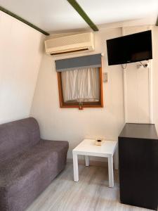 een kleine woonkamer met een bank en een tafel bij Camping Las Palmeras in Crevillente