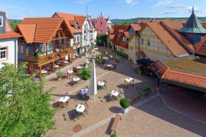 een uitzicht over een stad met tafels en stoelen bij Seehotel Niedernberg - Das Dorf am See in Niedernberg