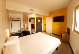um quarto com uma cama branca e uma televisão em B&B HOTEL Nice Stade Riviera em Nice