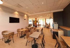 un restaurant avec des tables et des chaises et une télévision dans l'établissement B&B HOTEL Nice Stade Riviera, à Nice