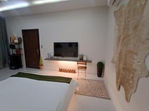a room with a bed and a tv on a wall at بوهيمي هومتيل Bohemia Hometel in Al ‘Azīzīyah