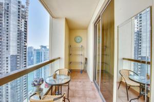 a balcony with tables and chairs and a view of a city at Bright apartment on the JBR Beach in Dubai