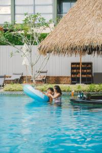 a woman and a girl in a raft in the swimming pool at Avani Plus Mai Khao Phuket Suites in Mai Khao Beach