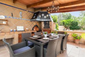 a patio with a table and chairs and a stove at Can Navarro in Cala Pi