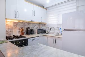 a kitchen with white cabinets and a counter top at Duplex Villa w Sea View Terrace in Kusadasi in Kusadası