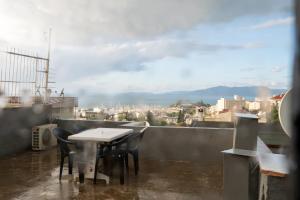 a table and chairs on a balcony with a view of a city at Duplex Villa w Sea View Terrace in Kusadasi in Kusadası
