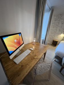 a wooden desk with a computer on top of it at Babolène Shabby Suite in Villefranche-de-Rouergue