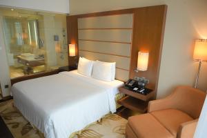 a hotel room with a bed and a chair at Courtyard by Marriott Kochi Airport in Nedumbassery