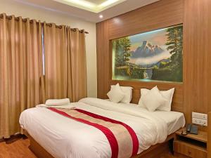 a bedroom with a bed with a painting on the wall at Hotel Dipjyoti in Kathmandu