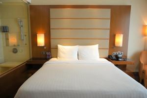 a large bed in a hotel room with a shower at Courtyard by Marriott Kochi Airport in Nedumbassery