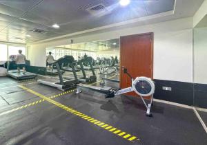 a gym with cardio machines and people in the background at luxury one bed room Apartment in dubai marina pinnacle tower in Dubai