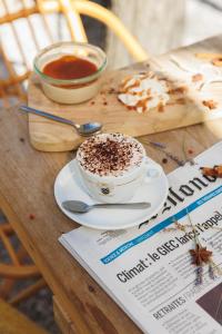 a cup of coffee on a table with a newspaper at Les appartements de Montpellier in Montpellier