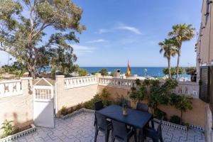 una mesa y sillas en un patio con vistas al océano en rentafive Nuevo Barbacoa Terraza Playa, en Gran Alacant