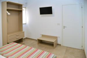 a bedroom with a bed and a tv on the wall at B&B Domus Terra Mare in Torre San Giovanni Ugento