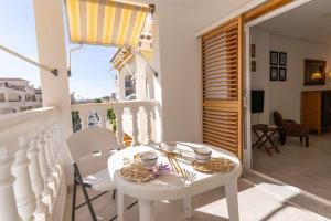 a white table and chairs on a balcony at 1 min Playa Terraza Piscina AA Garaje in Santa Pola