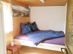 a bedroom with a bed with a purple comforter at Ferienhaus Signina in Danis