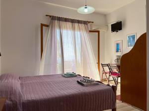 a bedroom with a bed with a purple blanket and a window at Anemone in Pelekas