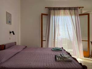 a bedroom with a bed and a window with towels on it at Anemone in Pelekas