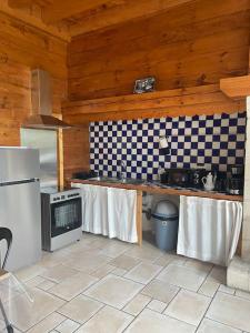 a kitchen with a stove top oven in a wooden kitchen at Logement 6 personnes avec SPA in Essômes-sur-Marne
