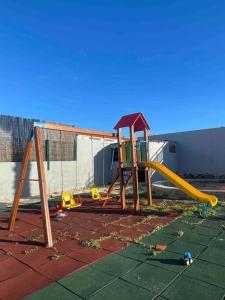 um parque infantil com um escorrega num quintal em Golden Breeze Holidays em Sagres
