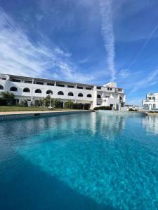 a large pool of blue water in front of a building at Golden Breeze Holidays in Sagres