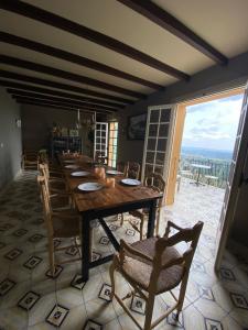 ein Esszimmer mit einem langen Holztisch und Stühlen in der Unterkunft Villa with panoramic views near Grasse- 2175 in Spéracèdes