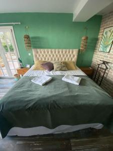 ein großes Bett in einem Schlafzimmer mit einer grünen Wand in der Unterkunft Villa with panoramic views near Grasse- 2175 in Spéracèdes