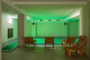 Habitación verde con sillas y piscina en GANZ HOTEL, en Ivano-Frankivsk