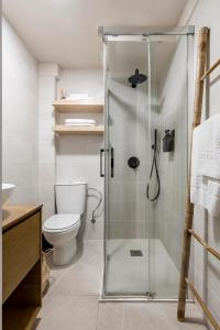 a bathroom with a toilet and a glass shower at Charming apartment central Madrid in Madrid